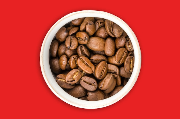 Coffee beans isolated on red background