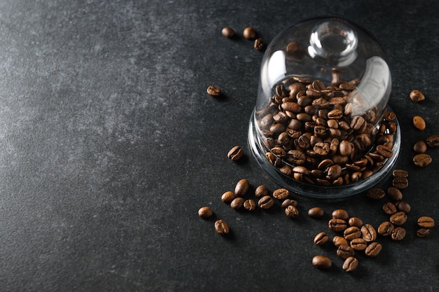 Coffee beans lie on a glass dish on a gray background