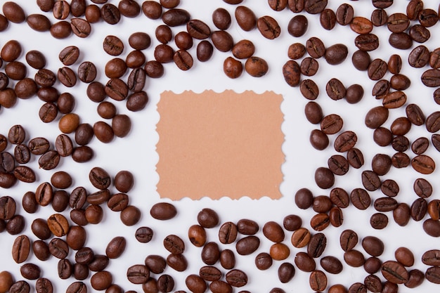 Coffee beans placed around blank paper for copyspace