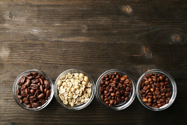 Photo coffee beans in saucers on wooden background