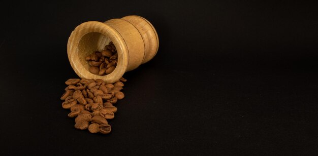 Coffee beans spilling out of a wooden bowl