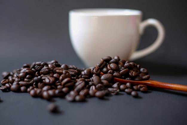 Coffee beans and white cups on a dark background