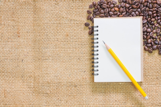 Coffee beans with notebook and a coffee cup 