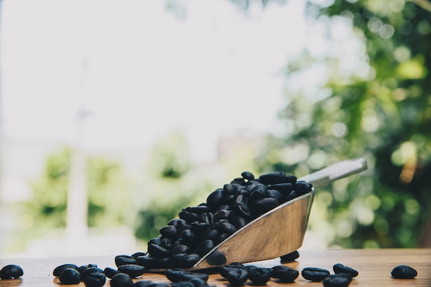 Coffee beans with scoop on table