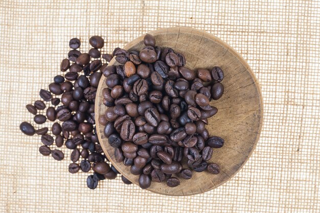 Coffee beans on wooden cutting board.