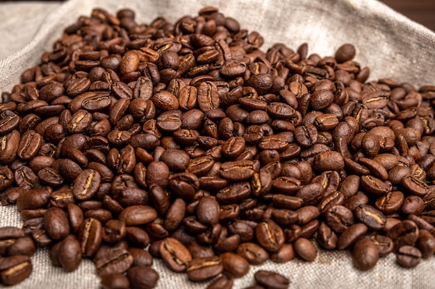 Coffee beans on a wooden table on black. View from above.