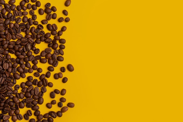 Coffee beans on a yellow background, other grains scattered around, concept