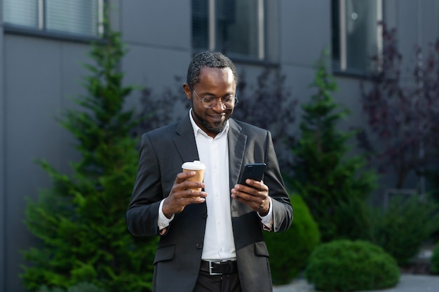 Coffee break a young africanamerican businessman freelancer stands on the street near the office