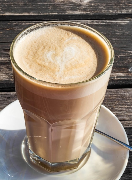 Coffee cafe latte macchiato in a high glass on a wooden background