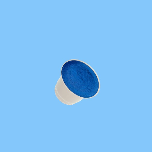 Coffee capsule for coffee machine on blue background Design element copy space.