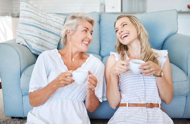 Coffee comic communication and mother with daughter on the living room floor of their house Elderly woman speaking giving advice and in conversation with her adult child with tea in the lounge