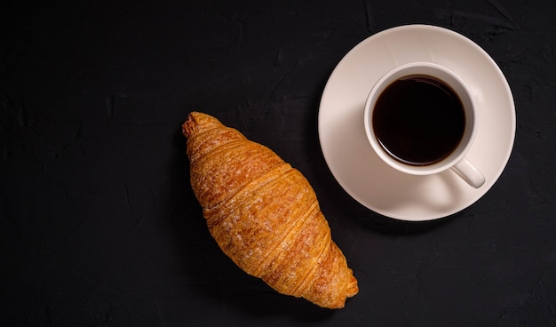 Coffee and croissant on a dark background