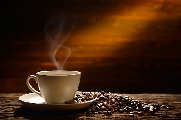 Coffee cup and coffee beans on old wooden background