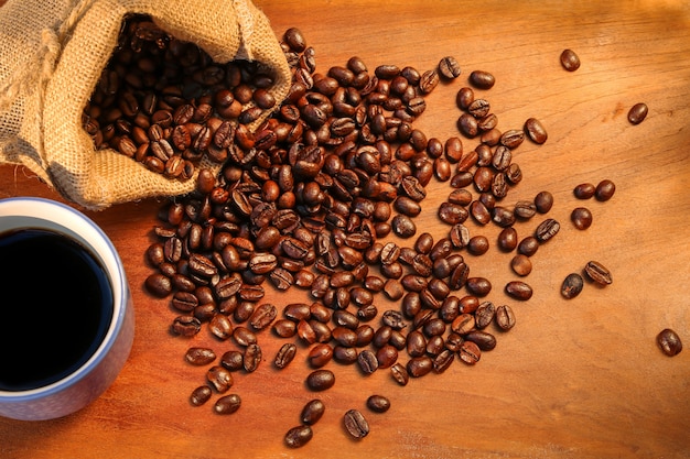 Coffee cup and coffee beans on table Cup of coffee, bag and scoop on old rusty background