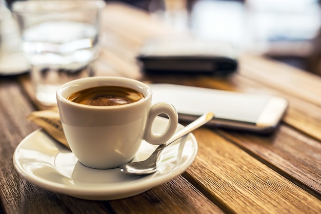 Coffee. Cup of coffee mobile phone on table on restaurant coffee