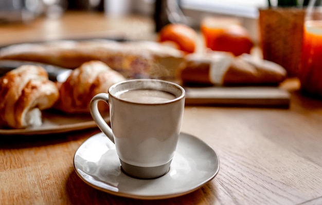 Coffee cup and croissants at kitchen table