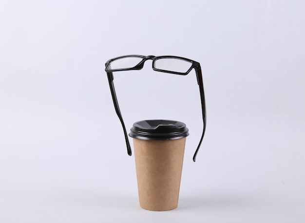 Coffee cup and floating glasses on gray background