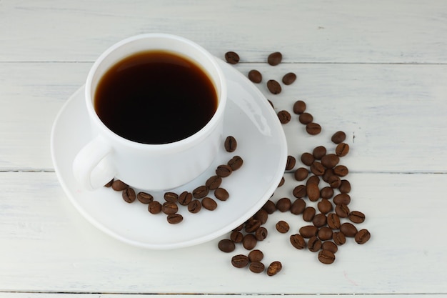 Coffee in a cup and grains on the table