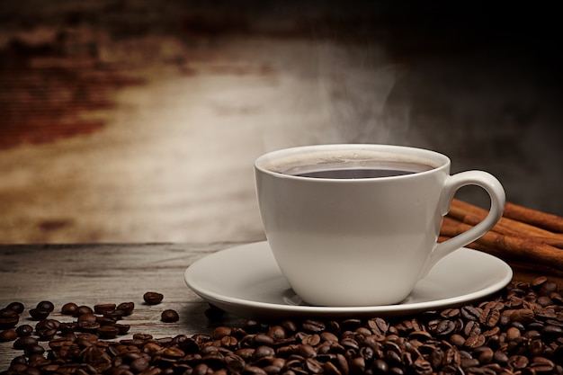 Coffee cup over grunge wooden background