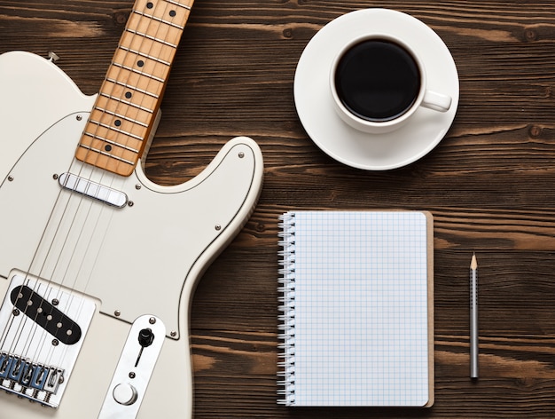 Coffee cup and guitar on wooden table