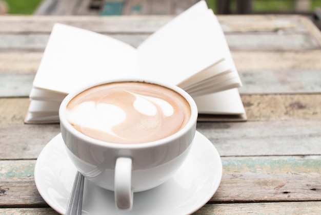 Coffee cup and gunge paper on old wood table background outdoor