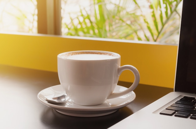 Coffee cup and laptop for business in coffee shop