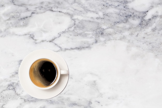 Coffee cup on marble table top view.