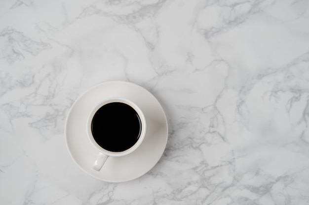 Coffee cup on marble texture table, black coffee cup in top view with copyspace