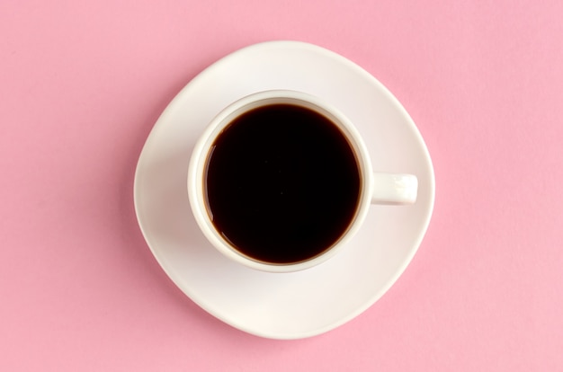 Coffee cup on pink surface. Flat lay