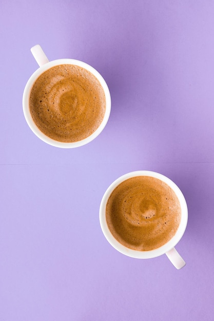 Coffee cup on purple background top view flatlay