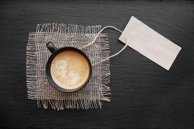 Coffee cup on rustic burlap and blank paper card