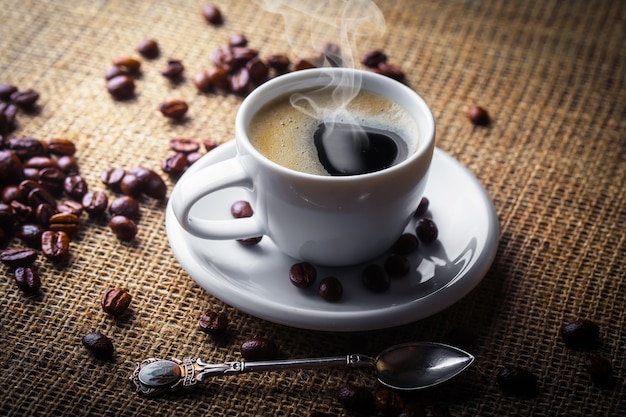 Coffee in a cup and saucer with coffee beans