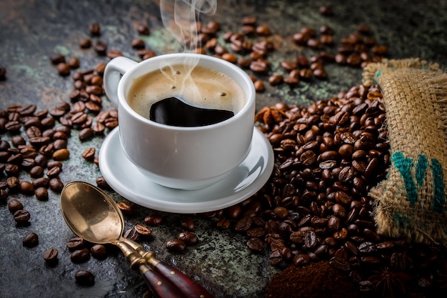 Coffee in a cup and saucer with coffee beans