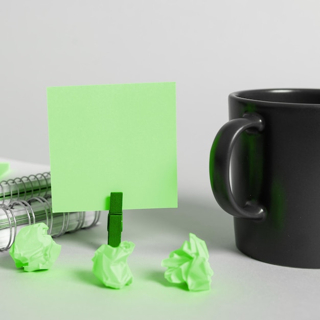 Coffee Cup Standing on Desk Important infrormation written on paper Different Office Supplies Pencils Pens Marckers Computer keyboard Text on wood table