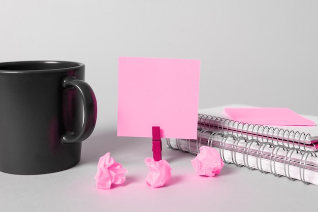 Coffee Cup Standing on Desk Important infrormation written on paper Different Office Supplies Pencils Pens Marckers Computer keyboard Text on wood table