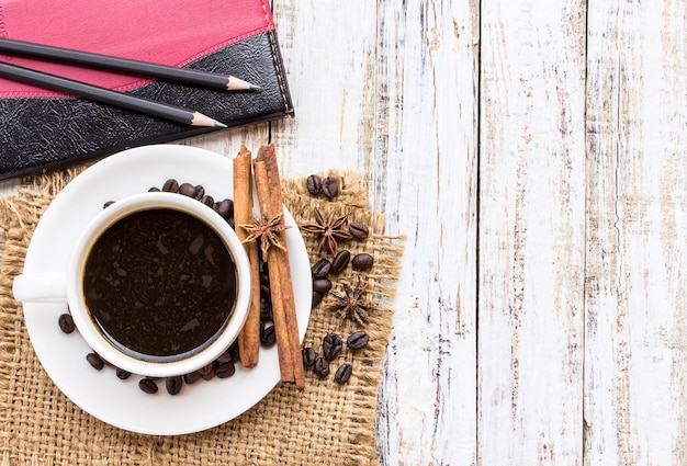 Coffee cup and stationary on wood table Top view with copy space