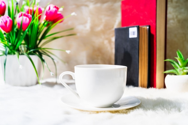 Coffee cup with book stacked on table