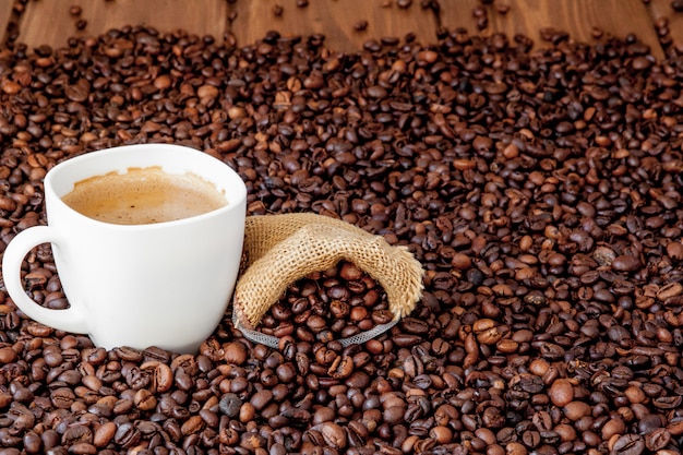 Coffee cup with coffee bag on wooden table. View from top