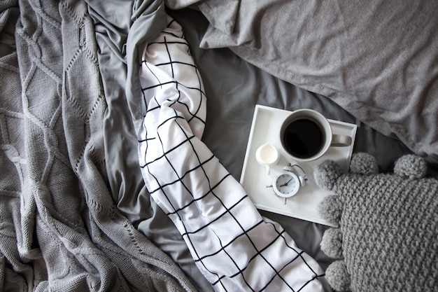 Coffee cup with milk on a tray in bed