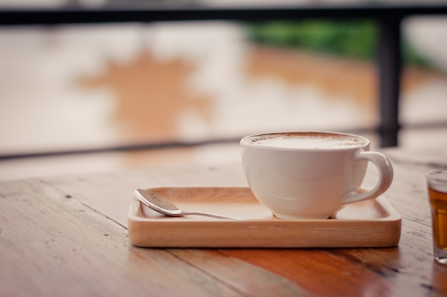 Coffee cup on wooden table surface background vintage style selective focus with copy space.