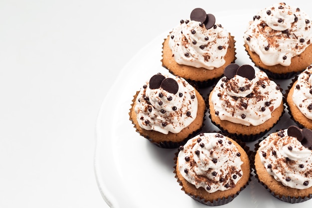 Coffee cupcakes with mocha buttercream and chocolate decorations on a white table