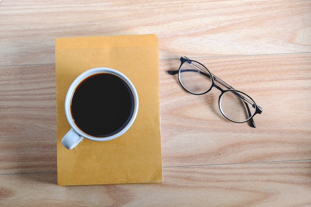 Coffee cups, books, glasses on wooden boards