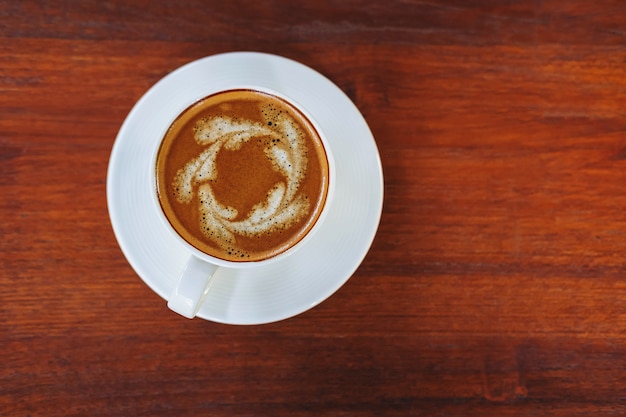 Coffee cups on a wooden table in a coffee shop background