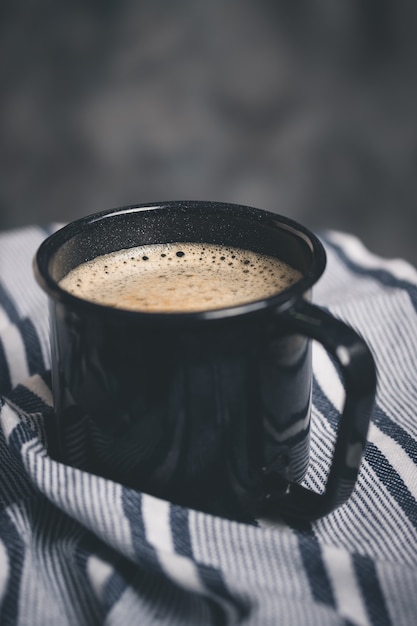 A coffee in a dark camping mug