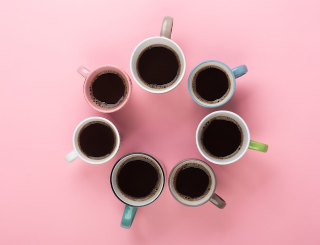 Coffee in the different cups on the pink background. Flatlay, cheerful day concept