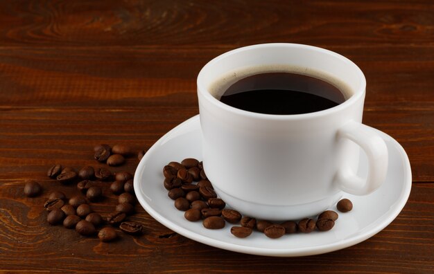 Coffee drink and beans in a cup on a wooden surface