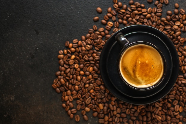 coffee drink in white cup and sprinkle coffee beans on the table