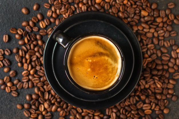 coffee drink in white cup and sprinkle coffee beans on the table