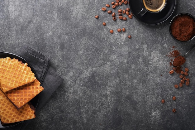 Coffee and dutch waffles Espresso coffee and dutch waffles or syrupwaffles cookies with chocolate on old on black concrete table Perfect syrupwaffles cookies for Breakfast Top view Mock up