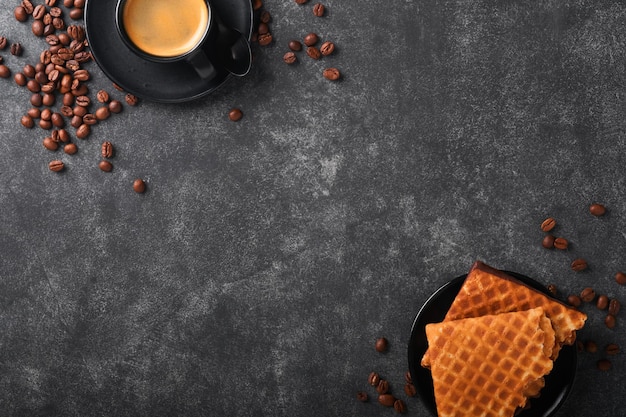 Coffee and dutch waffles Espresso coffee and dutch waffles or syrupwaffles cookies with chocolate on old on black concrete table Perfect syrupwaffles cookies for Breakfast Top view Mock up